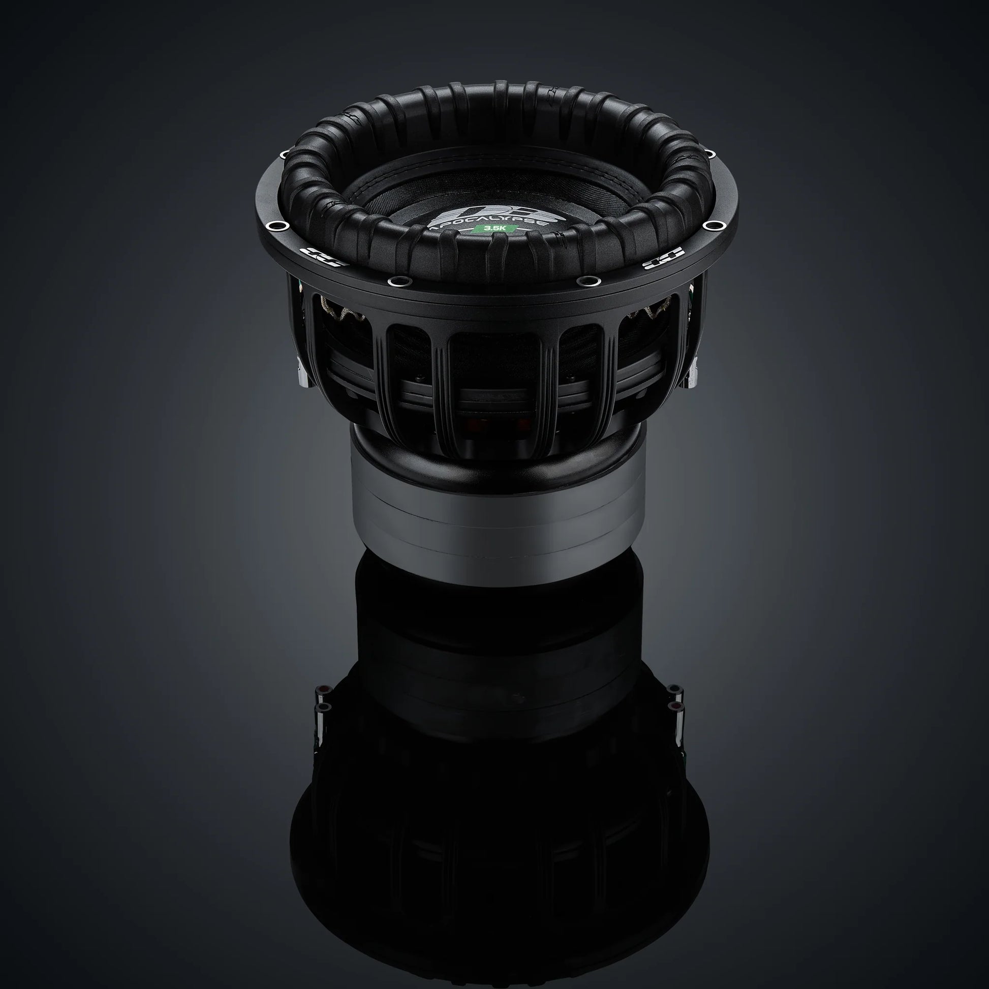 Il subwoofer Deaf Bonce Apocalypse DВ-3.5K da 12 è caratterizzato da un cono a coste e da un telaio in metallo, raffigurato su una superficie scura e riflettente con uno sfondo sfumato.