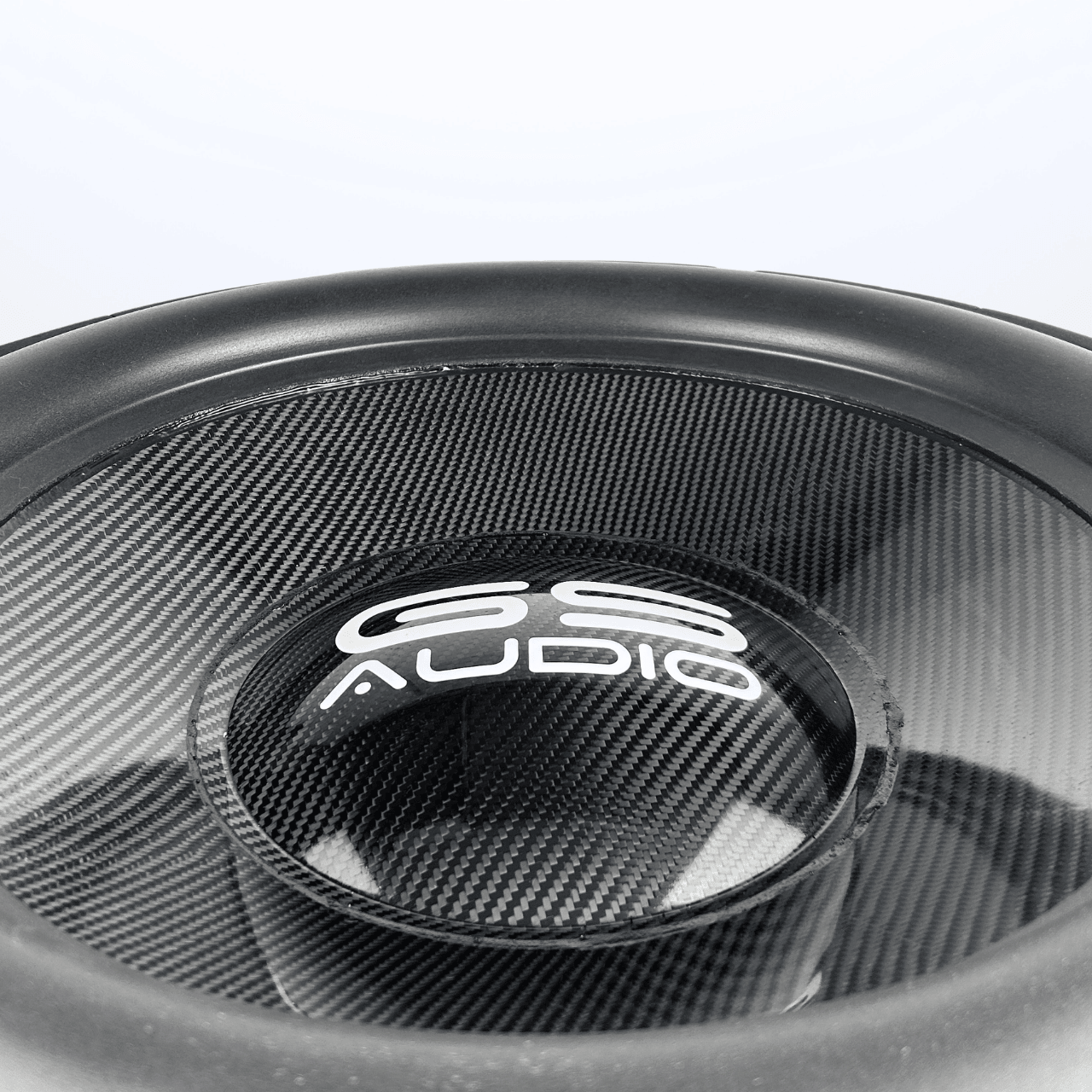 Nahaufnahme eines schwarzen GS Audio Gold 10000 MK2 21″-Lautsprechers mit Carbon-Optik und Logo auf der Staubschutzkappe, vor einem schlichten weißen Hintergrund.