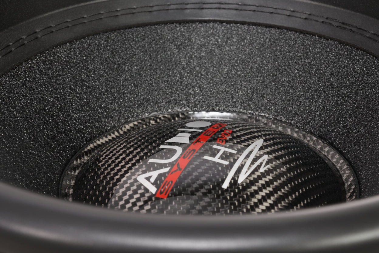 Gros plan sur un cône de haut-parleur Helon H15 EVO2 en fibre de carbone noire de la marque Audio System, avec le logo blanc et rouge sur le cache-poussière du caisson de basses de 15 pouces.