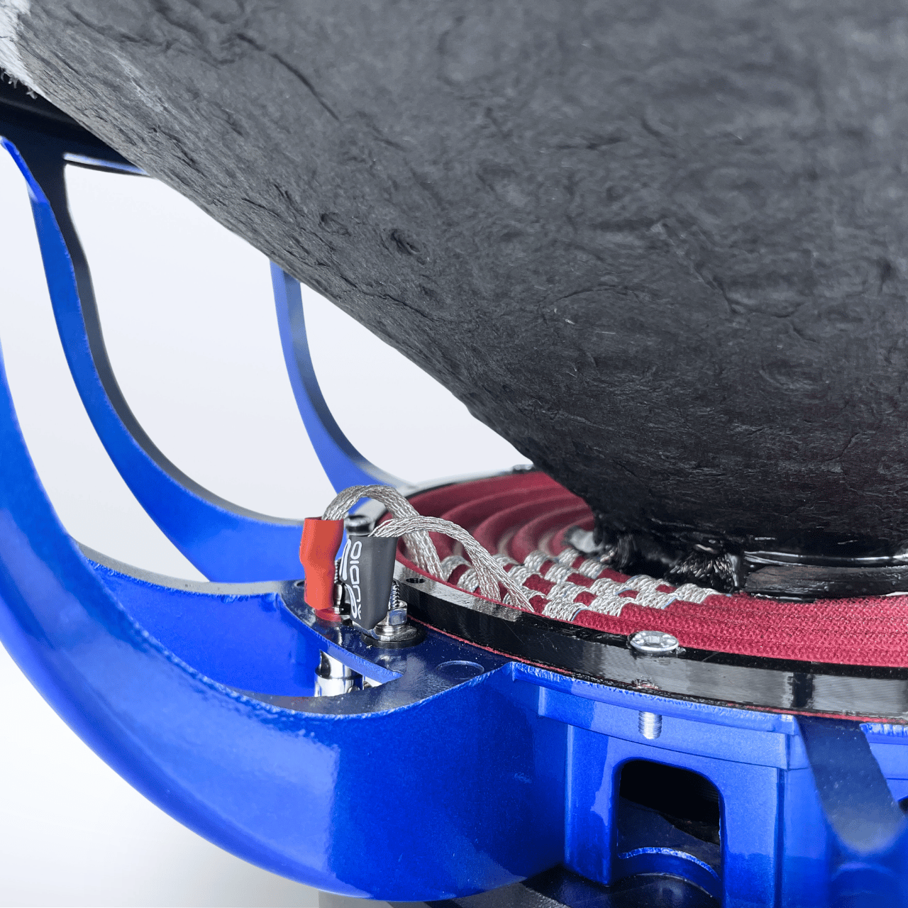 Nahaufnahme des GS Audio Platinum 4000 MK3 18″-Lautsprechers: blauer Metallrahmen, rot-weiß geflochtenes Kabel am Anschluss, darüber ein schwarzer Konus.