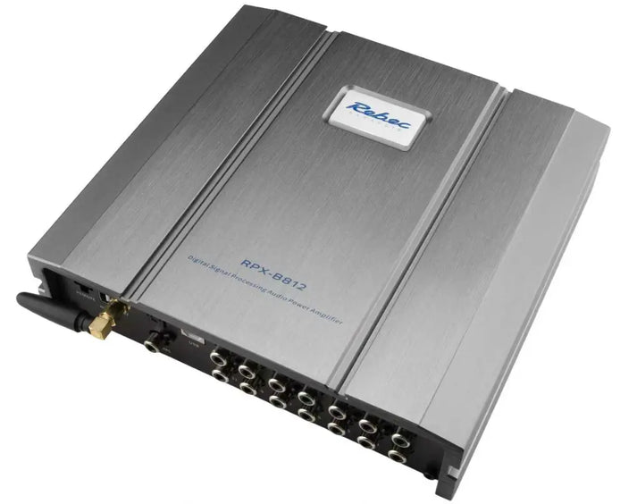 De Rebec RPX-B812 is een zilverkleurige DSP-versterker met talrijke in- en uitgangen, Bluetooth 5.4 en een zichtbaar Rebec-logo aan de bovenkant.