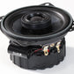 Sistema de audio RXC100 EVO3: altavoz coaxial redondo negro de 4″ con cono de fibra de vidrio, cableado a la vista, serie R, mostrado en ángulo sobre un fondo blanco.