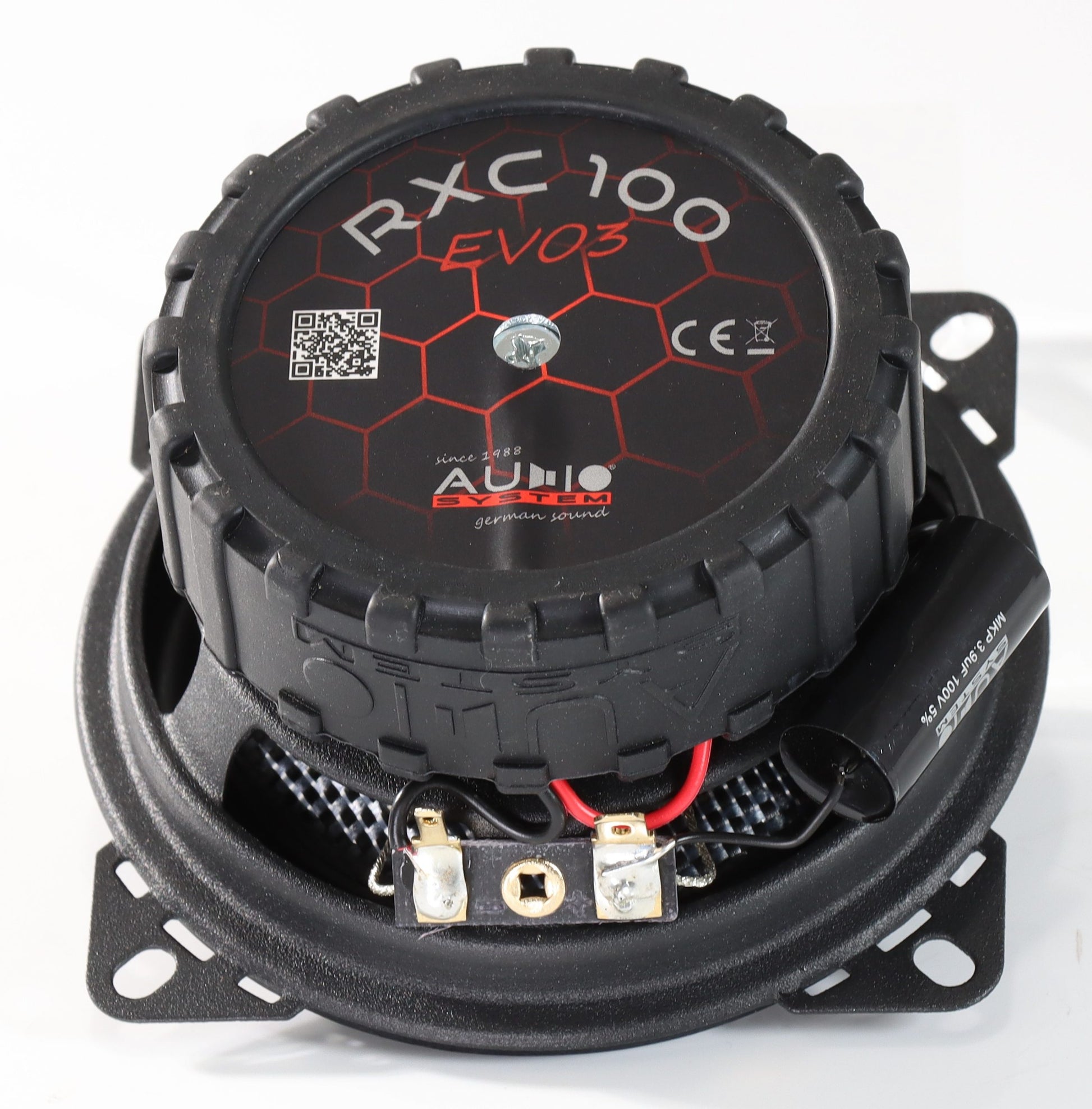 Sobre un fondo blanco se muestra un altavoz coaxial negro de 4 pulgadas del sistema de audio RXC100 EVO3, con membrana de fibra de vidrio, un patrón hexagonal rojo, cableado y terminales metálicos.