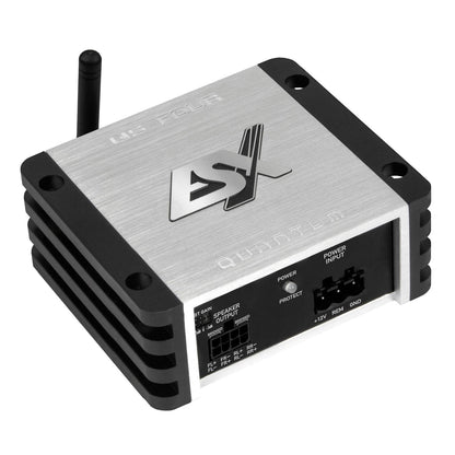 LESX QS-FOUR-BT est un amplificateur DSP compact à 4 canaux, de couleur argentée, doté dailettes latérales noires, dune antenne et de plusieurs ports dentrée/sortie en façade.