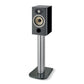 Un diffusore Focal ARIA EVO X N°1 nero poggia su un elegante supporto argentato con base in vetro.