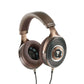 De Focal Clear Mg over-ear hoofdtelefoon heeft een gaasrooster, gevoerde hoofdband en geperforeerde oorkussens voor een eersteklas geluidskwaliteit tegen een witte achtergrond.
