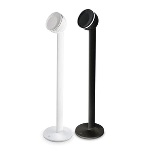 Dos soportes de altavoz Focal Dôme Stativ, uno blanco y otro negro, cada uno con una base redonda y un altavoz circular montado, se sitúan uno junto al otro sobre un fondo blanco.