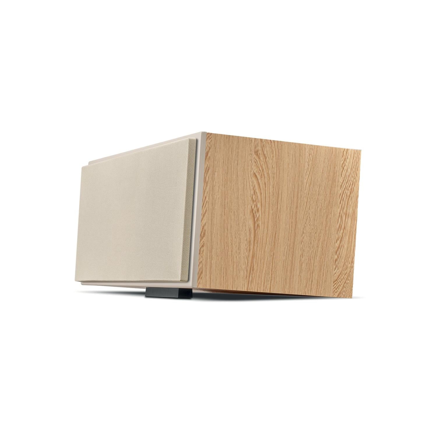 Der Focal Theva Center ist ein moderner, rechteckiger Lautsprecher aus hellem Holz mit einem beigen Gitter, das schräg vor einem weißen Hintergrund steht.