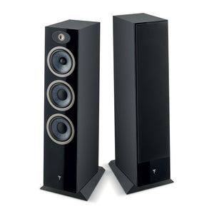 Dos altavoces altos Focal Theva N°3 se sitúan uno al lado del otro; uno muestra tres transductores y un tweeter, el otro está cubierto con una rejilla negra.