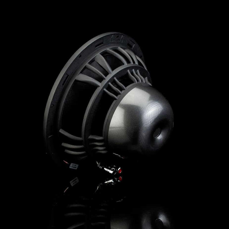 El subwoofer Aero 10 de Gladen Aerospace cuenta con un cono metálico, un marco robusto y conectores rojos y negros, lo que lo hace ideal para sistemas de alta fidelidad para coche de gama alta, tal y como se muestra sobre un fondo negro.