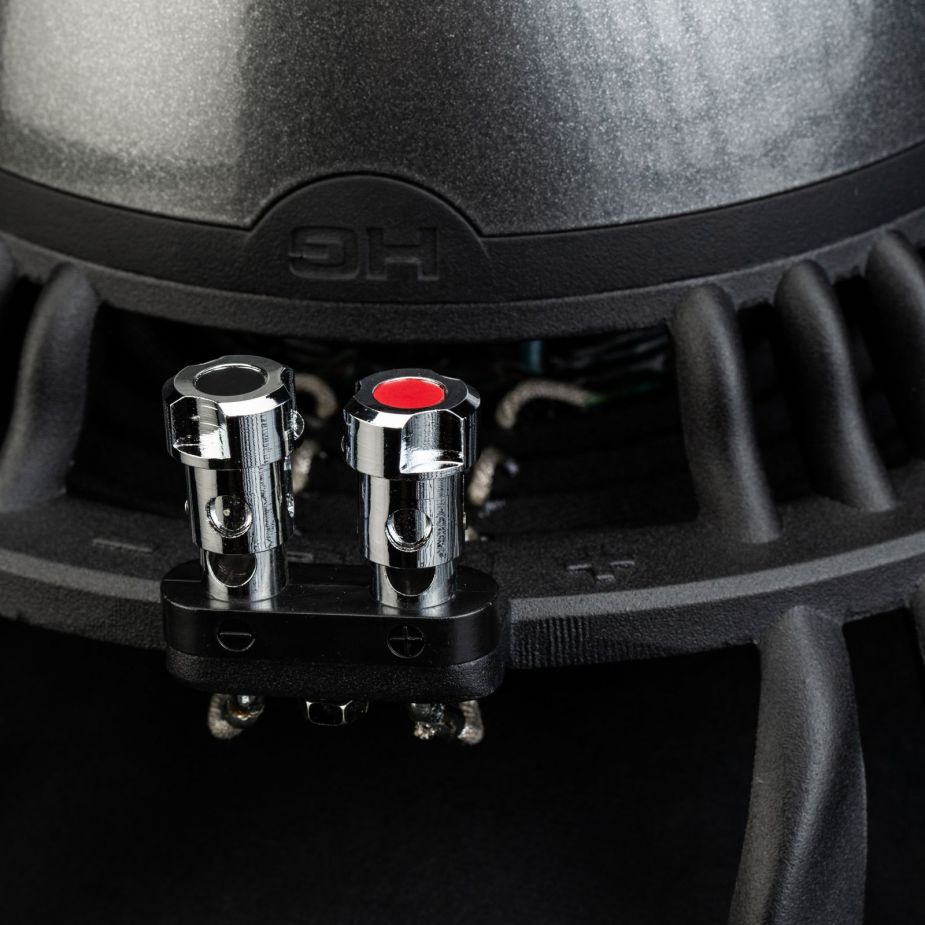Primer plano de los terminales Aero 10 de Gladen Aerospace en una carcasa negra, etiquetados con +/−: ideales para cualquier configuración de subwoofer de alta gama para el sistema de audio del coche.