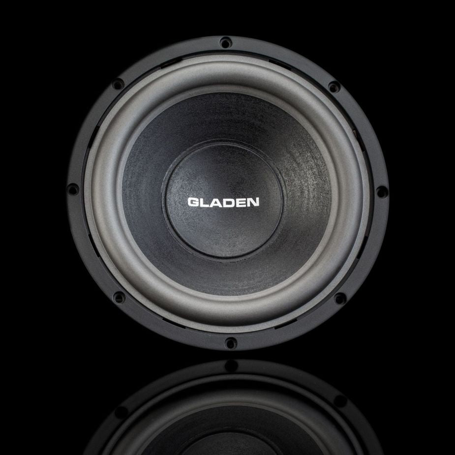 Se muestra un subwoofer redondo y negro «Aero 10» de Gladen Aerospace sobre un fondo negro, con el cono y el borde a la vista, ideal para instalaciones de audio para coche de alta gama.