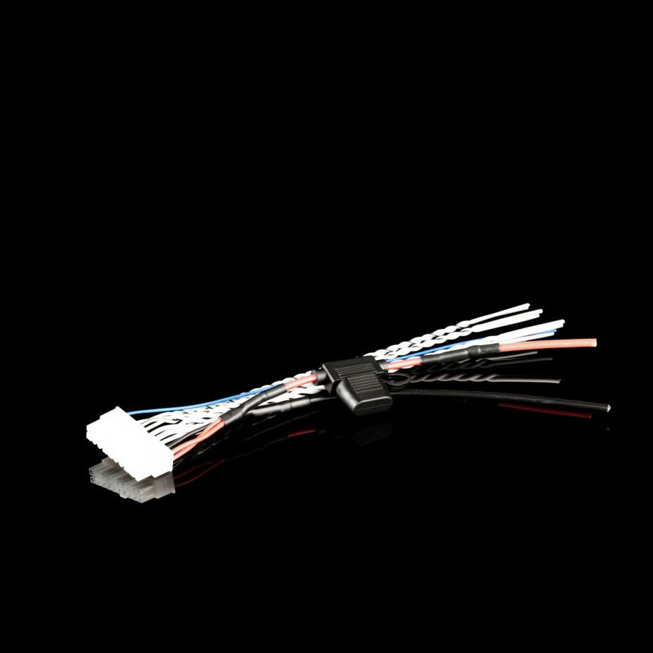 Un set di cavi colorati con connettori e un morsetto nero, ideale per lamplificatore PlugPlay Gladen EX-80C1, raffigurato su una superficie nera riflettente.