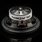 Un primer plano del subwoofer Gladen GS08-Slim, con conectores metálicos y el logotipo de la marca, sobre un elegante fondo negro.