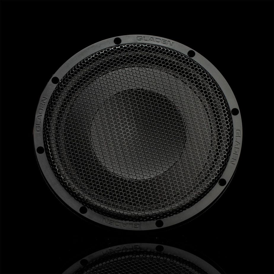Vista frontale: il Gladen GS10-Slim, un subwoofer rotondo da 10 pollici di colore nero con griglia esagonale, offre un suono potente su uno sfondo completamente nero.
