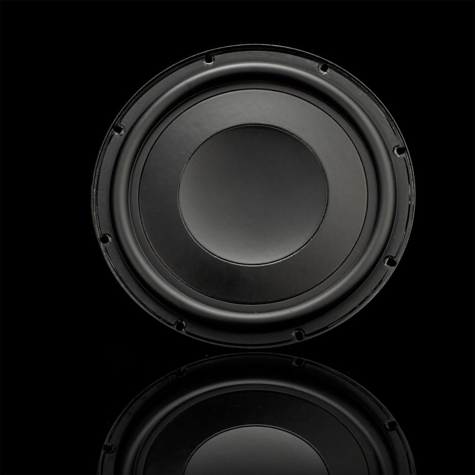 A Gladen GS10-Slim Subwoofer stands against a black background, its powerful bass suggested by a subtle reflection beneath its clear circular edge.