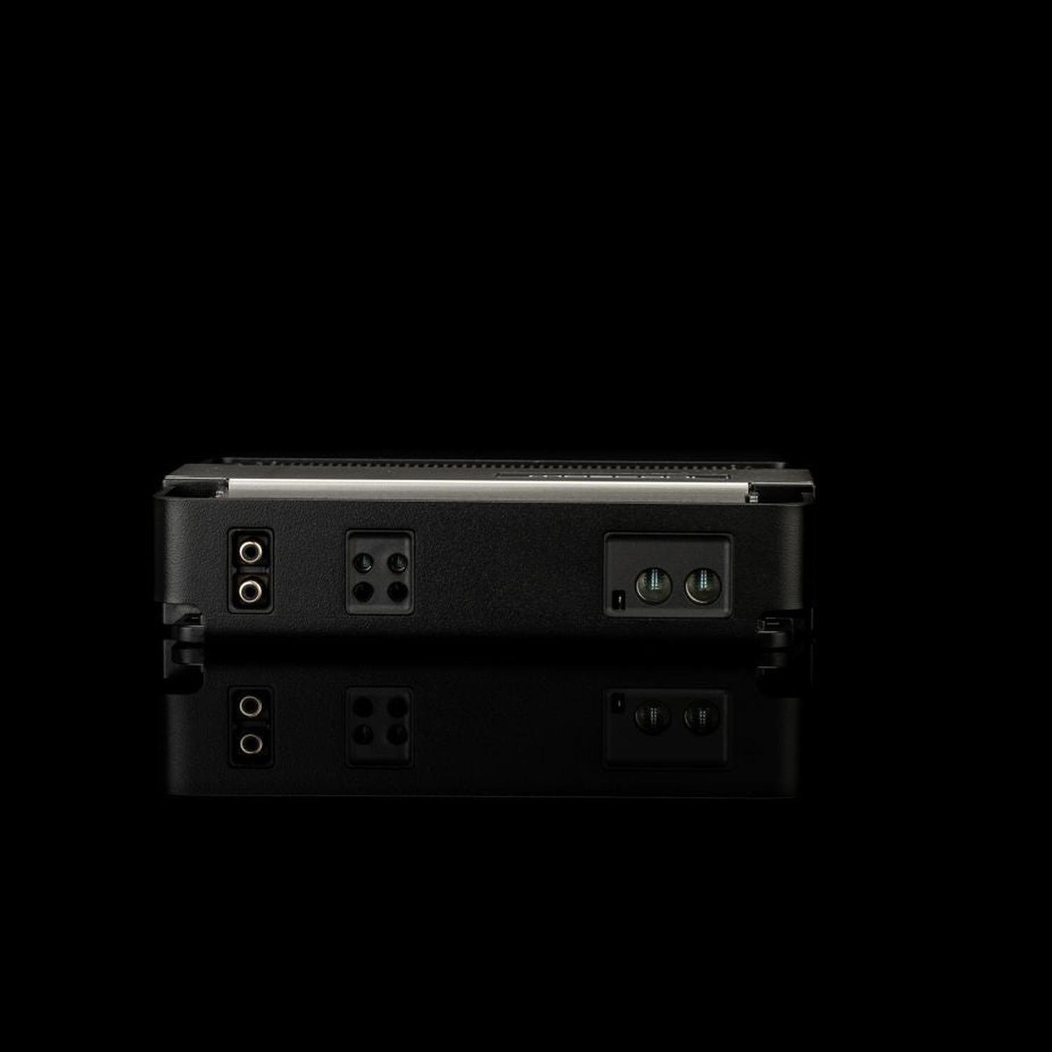 Un amplificatore per auto Gladen Mosconi Pro 1|10 evo di colore nero è raffigurato su uno sfondo nero, con le porte e i connettori messi in risalto da un leggero riflesso sottostante.