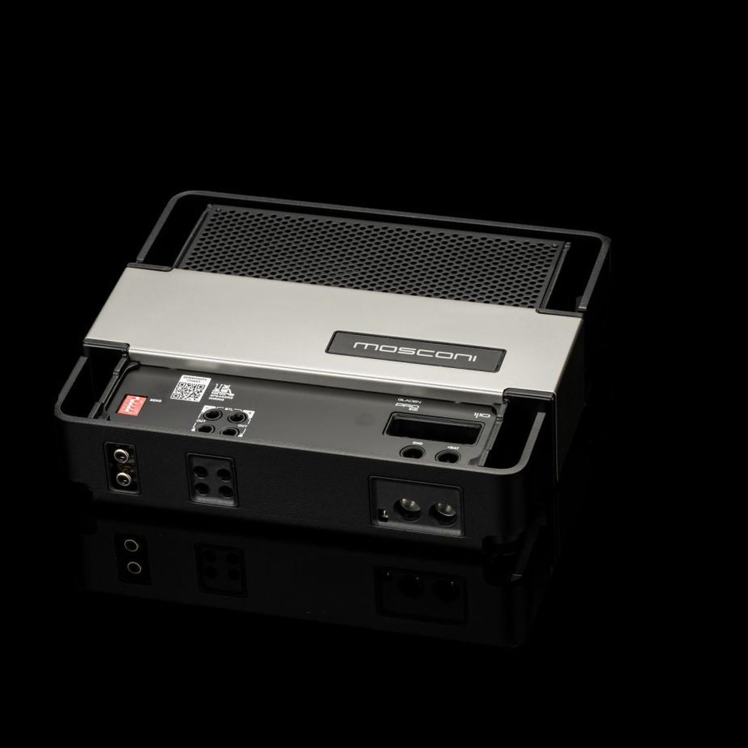 Un amplificatore per auto Gladen Mosconi Pro 1|10 evo con involucro in metallo è raffigurato su uno sfondo nero, con le porte e i connettori sul pannello posteriore ben visibili.