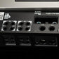 Primo piano del retro dellamplificatore «Gladen Mosconi Pro 4|10-AAB EVO» con uscite contrassegnate, terminali per altoparlanti e connettori GND e +BAT per il vostro impianto audio per auto.