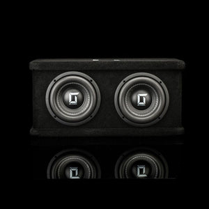 The Gladen Sigma SSW065 Dual, a black subwoofer with two 6.5 speakers and silver Sigma logos, is set against a dark backdrop with a subtle reflection underneath.