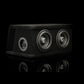 El Gladen Sigma SSW065 Dual, un subwoofer con carcasa negra y dos altavoces de 6,5 pulgadas, descansa sobre una superficie brillante y resalta el estilo Sigma sobre un fondo oscuro.