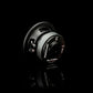 Il Gladen Sigma SSW065, un subwoofer nero da 5 pollici con parte centrale e connettori argentati, perfetto per linstallazione nelle auto di piccole dimensioni, viene presentato su una superficie nera riflettente.