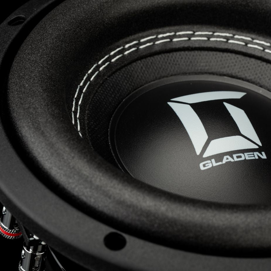 Primo piano dellaltoparlante Gladen Sigma SSW065, ideale per linstallazione su auto di piccole dimensioni, con cuciture decorative bianche e un logo geometrico sulla membrana centrale.