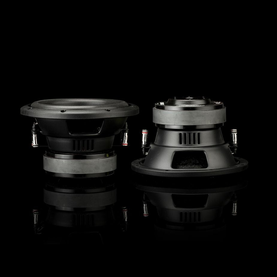 Dos subwoofers negros de 8 pulgadas del modelo Gladen Sigma SSW08, colocados sobre una superficie reflectante —que se muestran aquí desde delante y desde atrás—, ponen de manifiesto el elegante diseño del sistema de audio para coche.