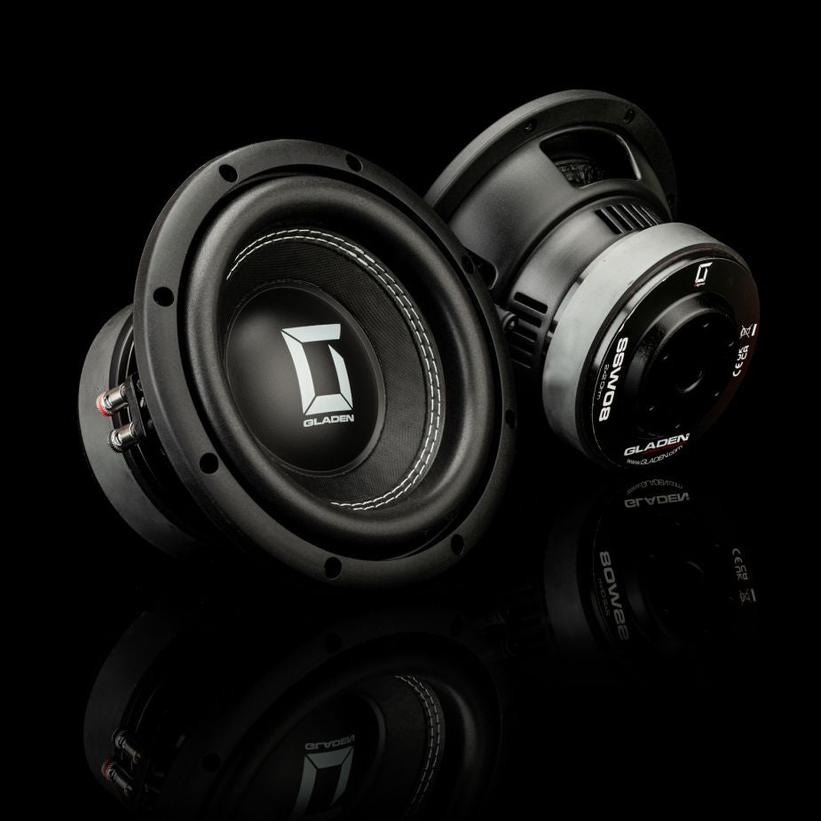 Due subwoofer Gladen Sigma SSW08 neri, uno in posizione verticale e laltro inclinato su una superficie lucida: ideali per impianti audio per auto ad alte prestazioni.