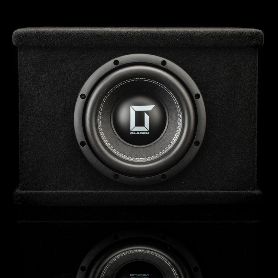 Un subwoofer Gladen Sigma SSW08-VB negro con una membrana de polialgodón de 800 W en una caja; vista frontal sobre fondo negro con su reflejo debajo.