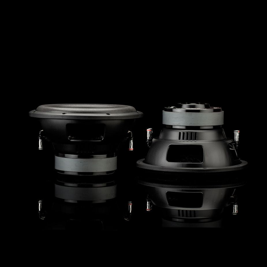 Due subwoofer Gladen Sigma SSW10 sono disposti uno accanto allaltro su una superficie riflettente, uno in posizione verticale e laltro con il retro rivolto verso lesterno, su uno sfondo nero uniforme.