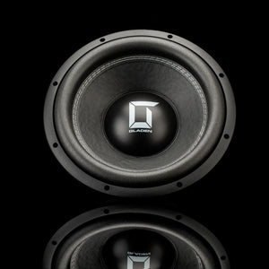 Un subwoofer dauto Gladen Sigma SSW12 noir, orné dun logo au centre, est représenté sur un fond noir, avec un léger reflet en dessous.