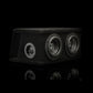 El Gladen Sigma SSWX065 Dual es una caja de subwoofer rectangular de color negro con dos altavoces de 6,5 y otro más pequeño, todo ello sobre un fondo negro.
