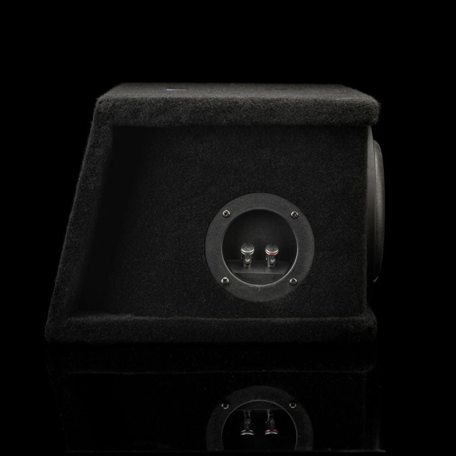 Una caja de subwoofer doble Gladen Sigma SSWX065, revestida de moqueta negra, para subwoofers de 6,5, con una placa de terminales redonda y dos bornes, sobre un fondo negro.