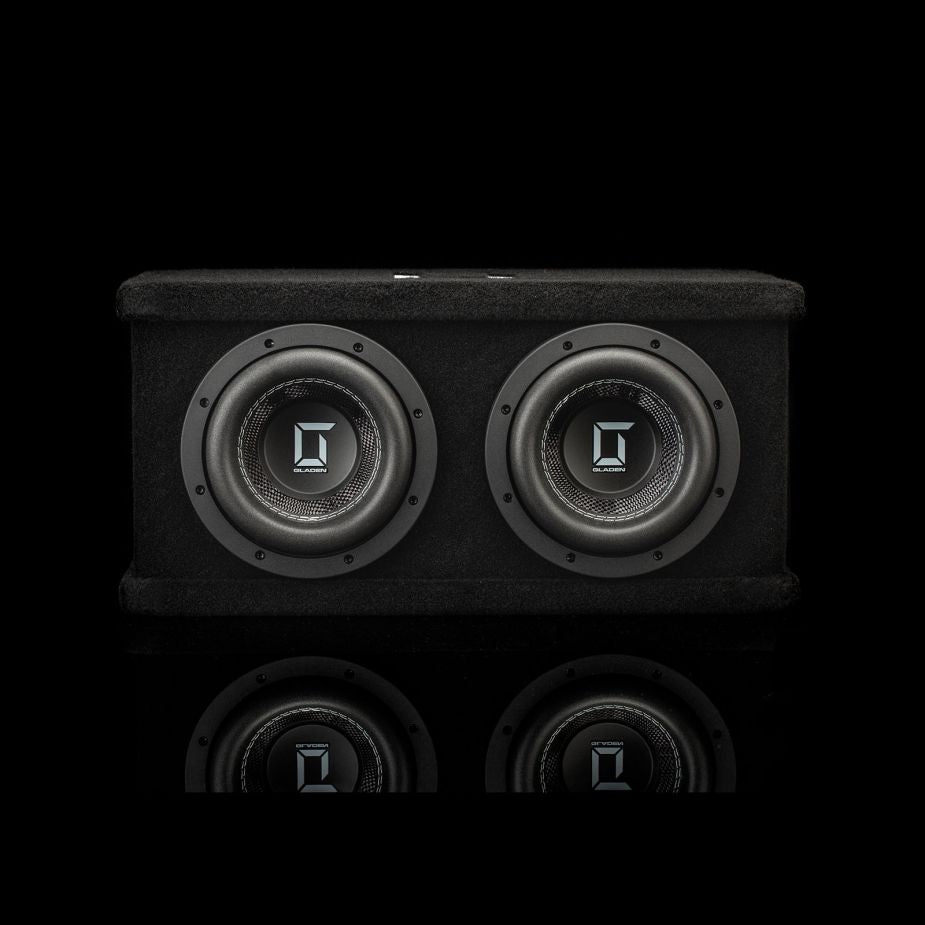 Un cabinet nero e rettangolare per il subwoofer doppio Gladen Sigma SSWX065, dotato di due driver da 6,5 pollici che si riflettono su una superficie lucida.