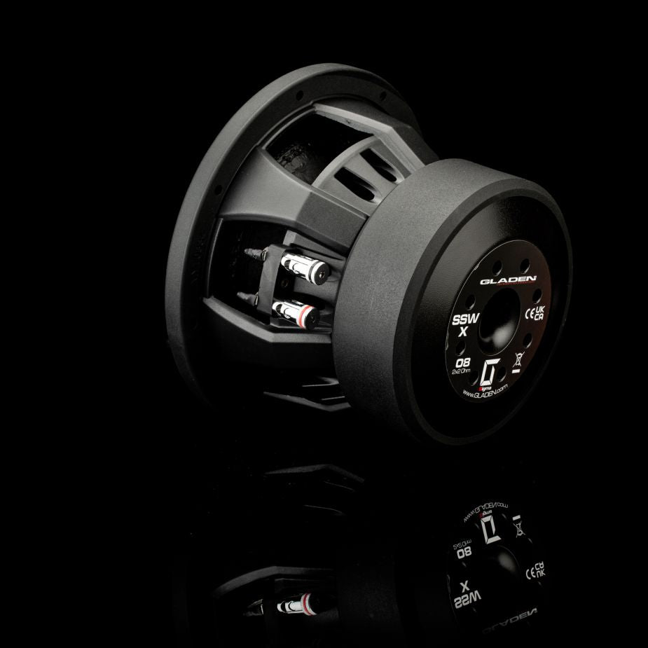El subwoofer Gladen Sigma SSWX08 de 8, que se muestra en color negro con los detalles técnicos en la parte trasera, destaca sobre un fondo brillante, lo que lo hace ideal para los aficionados al audio para coche.