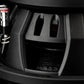 Primo piano di un subwoofer Gladen Sigma SSWX08, che mostra il telaio ventilato e il cablaggio sul lato sinistro dellimpianto audio per auto.