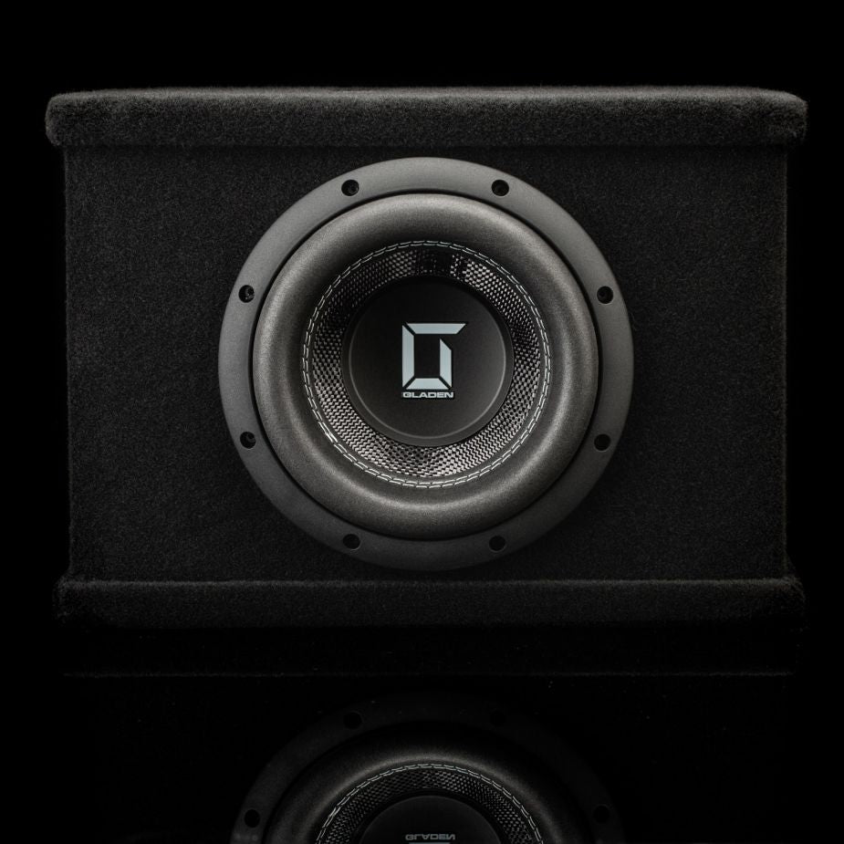 Gladen Sigma SSWX08VB: Black 8 subwoofer in a rectangular enclosure with a silver logo centered on the cone, shown on a black background.