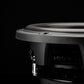 Primer plano del subwoofer Gladen Sigma SSWX10 sobre un fondo oscuro, en el que se destacan especialmente su marco, su membrana y sus conexiones para sistemas de audio para coche.