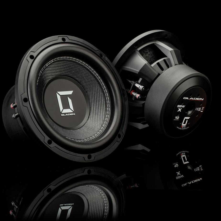 Dos subwoofers Gladen Sigma SSWX10 negros expuestos sobre un fondo negro, que destacan por su diseño de alta gama, perfectos para cualquier sistema de audio para coche de alto rendimiento o configuración de subwoofers.