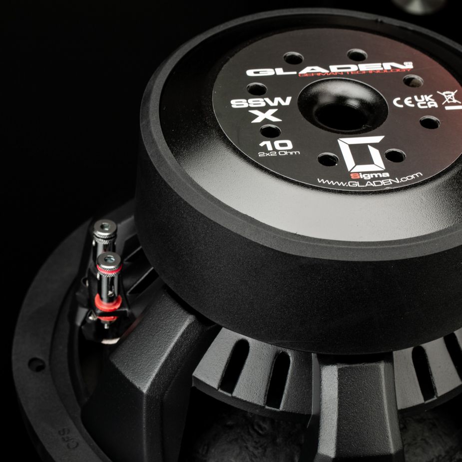 Primer plano del subwoofer Gladen Sigma SSWX10, en el que se aprecian la etiqueta de la marca, los terminales y el marco metálico; ideal para sistemas de audio para coche de alta gama.