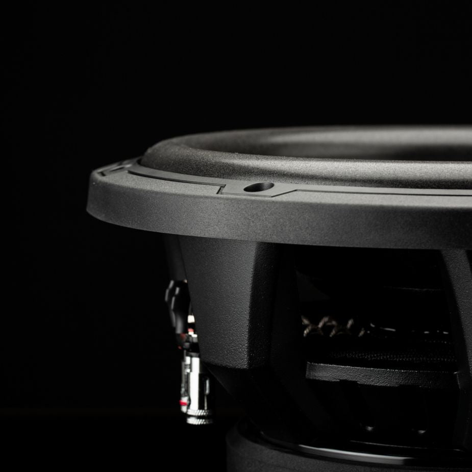 Primo piano del subwoofer Gladen Sigma SSWX10 su uno sfondo scuro, con particolare risalto alla cornice, alla membrana e ai connettori per impianti audio per auto.