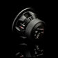 Il subwoofer Gladen Sigma SSWX10, qui raffigurato con cavi argentati e rossi su uno sfondo nero lucido, è ideale per impianti audio per auto di alta qualità.