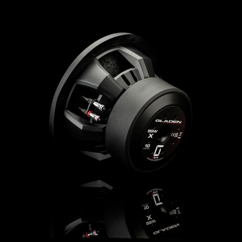 Il subwoofer Gladen Sigma SSWX10, qui raffigurato con cavi argentati e rossi su uno sfondo nero lucido, è ideale per impianti audio per auto di alta qualità.