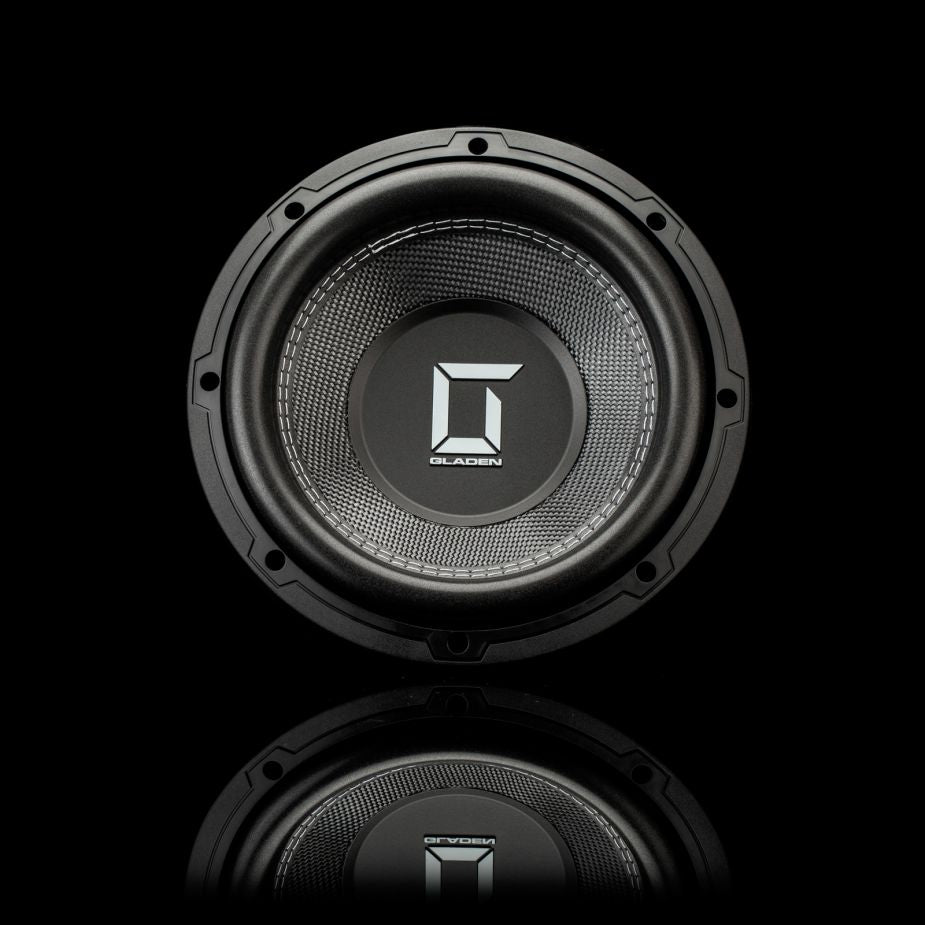 Un subwoofer Gladen Sigma SSWX10 nero presenta il logo G argentato, raffigurato su uno sfondo nero con il proprio riflesso. Ideale per impianti audio per auto di alta qualità.