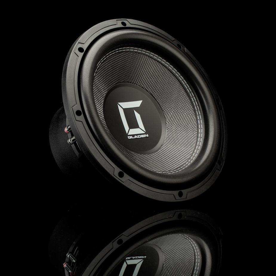 Un subwoofer Gladen Sigma SSWx12 con una membrana negra texturizada, fotografiado en ángulo sobre una superficie negra brillante.