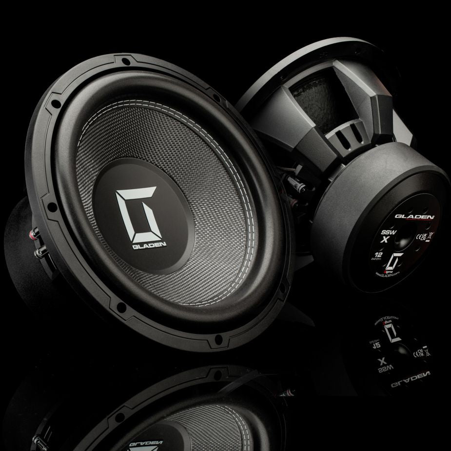 Su uno sfondo nero sono raffigurati due subwoofer Gladen Sigma SSWx12: in uno si vede la membrana da 12 pollici, nell’altro si distinguono i dettagli sul retro e sui lati.