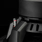 Primo piano della base del subwoofer Gladen Sigma SSWx12 con un connettore a terminali a filo visibile su uno sfondo scuro.
