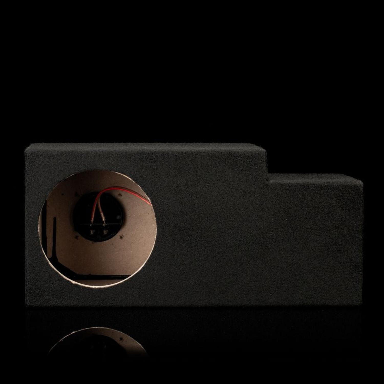 Un alloggiamento per subwoofer del tipo “Gladen Subbox-Buz.1”, nero con un’apertura circolare e cavi a vista, su sfondo nero.