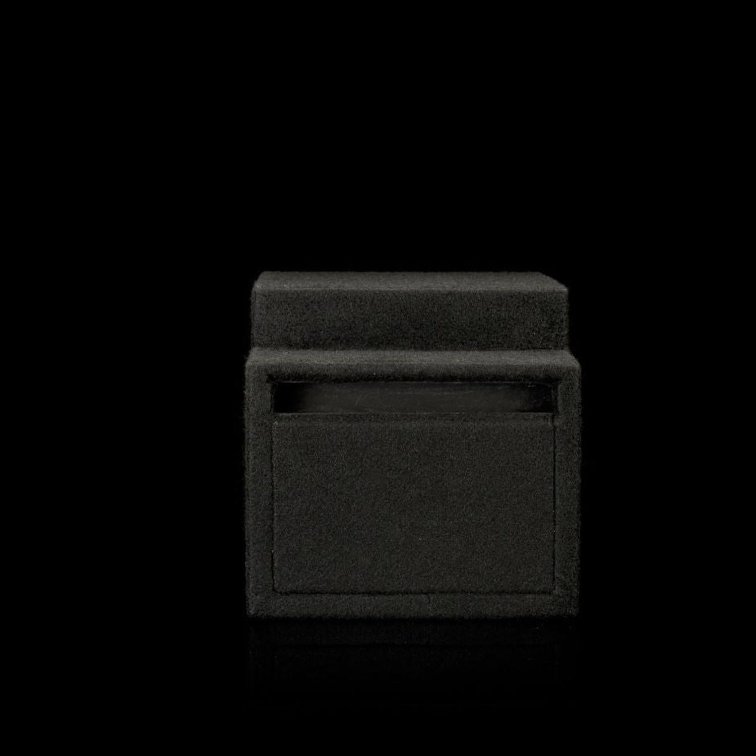 Un subwoofer Gladen Subbox-Buz.1 con coperchio chiuso è posizionato su uno sfondo nero, mimetizzandosi con dettagli visibili minimi.